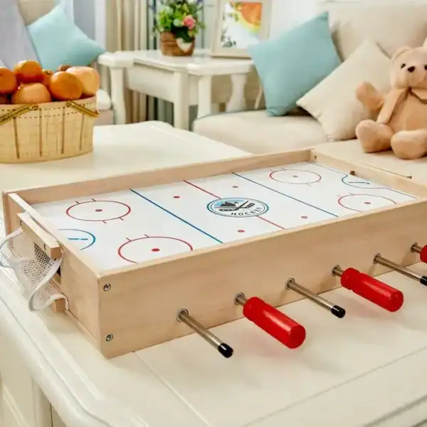 Mini table hockey game on living room table.