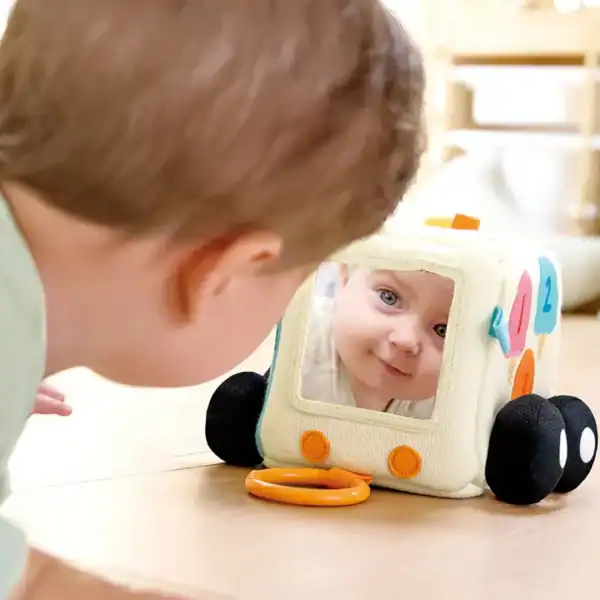 Baby looks at toy with mirror reflection