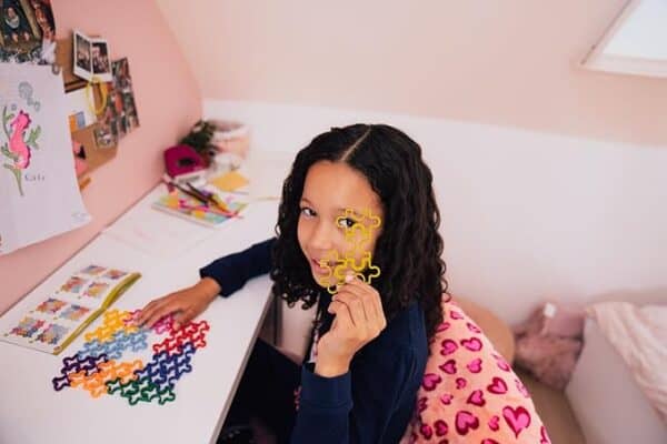Child playing with colorful puzzle pieces at desk.