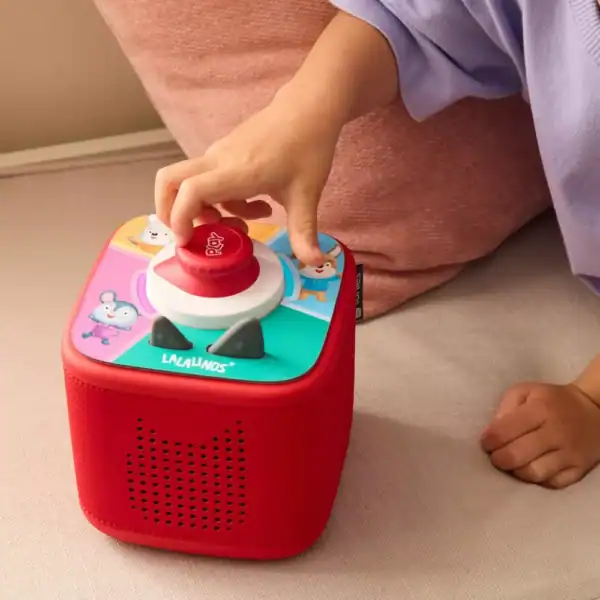 Child playing with colorful toy speaker.