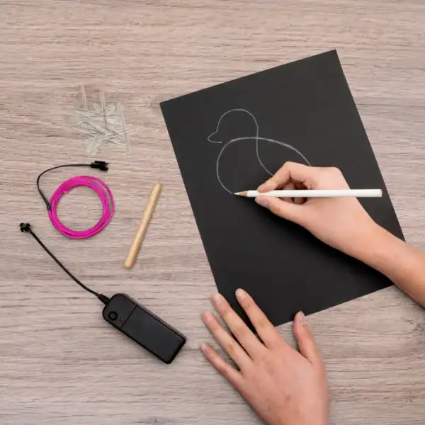 Tracing duck outline on black paper with tools