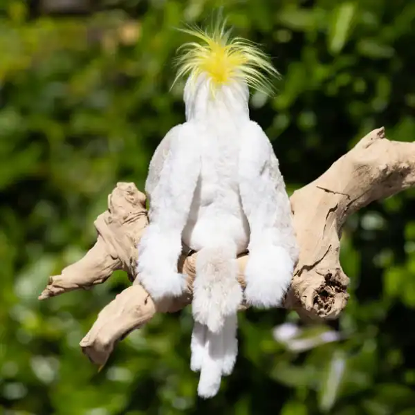 Stuffed cockatoo toy on a tree branch