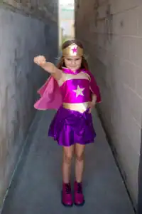 Child dressed as superhero with pink costume.