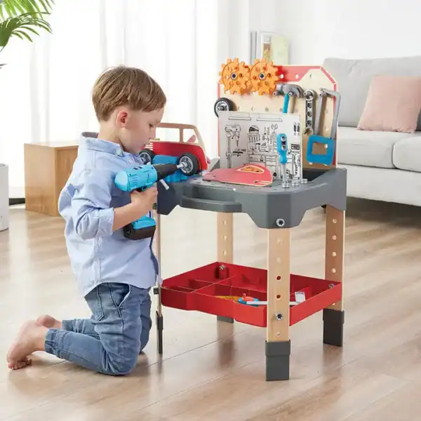 Child playing with toy workbench and tools.