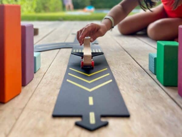 Child playing with toy car on wooden floor