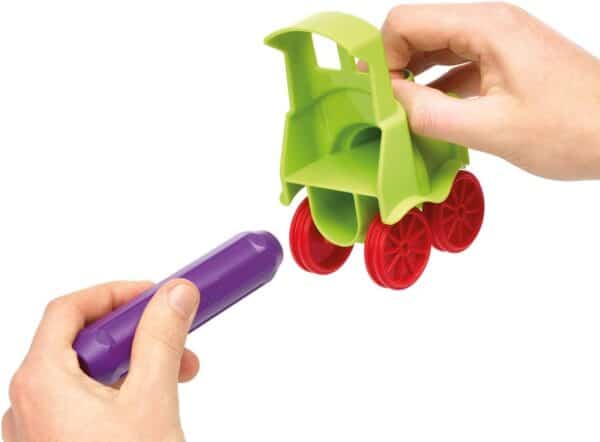 Hands assembling toy train parts.