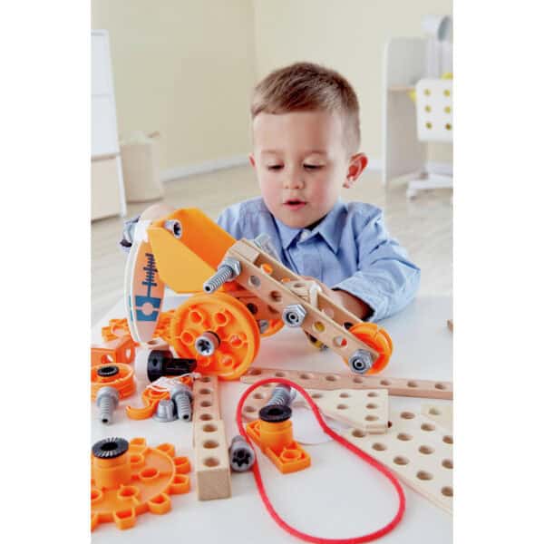 Child building with construction toy at table.