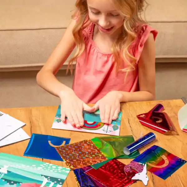 Girl making colorful craft with foil papers.