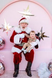 Santa holding baby, festive pink background