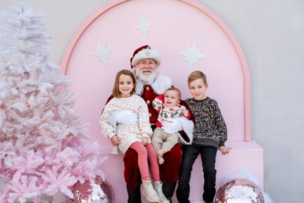 Santa with three kids on pink background.