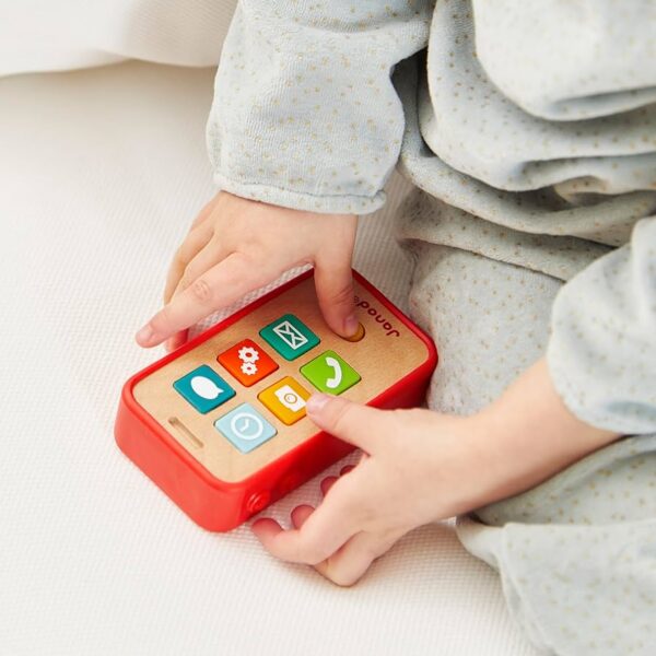 Child playing with toy phone in pajamas.