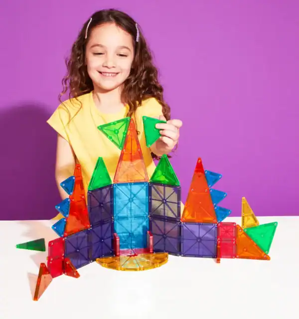 Girl building with colorful magnetic tiles