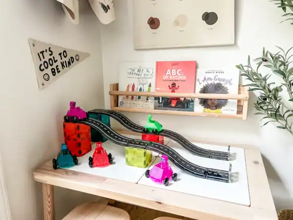 Kids' playroom with books and toy race track.