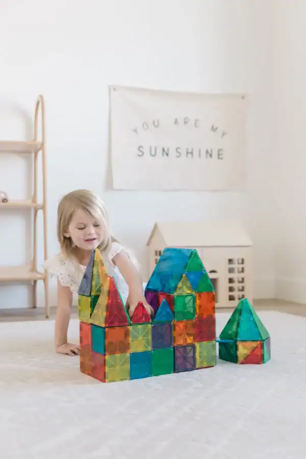 Child building colorful magnetic tile castle