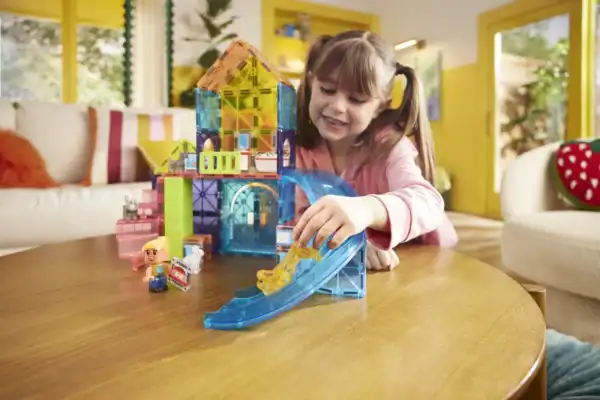 Child playing with colorful toy house and slide.