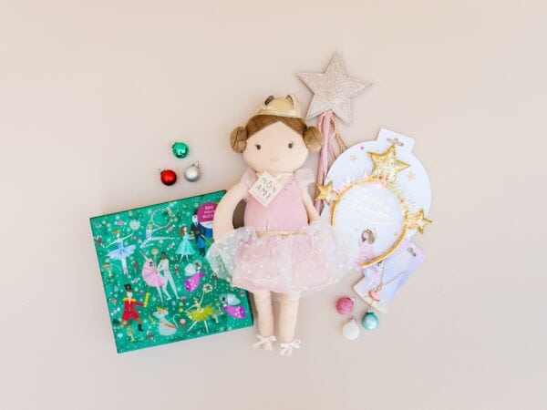 Doll with puzzle and star accessories on beige background.