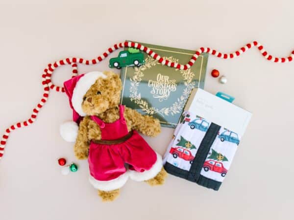 Christmas teddy bear, book, quilt, and decor arrangement.