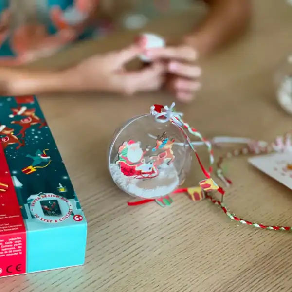 Child crafting Santa-themed Christmas ornament decoration.