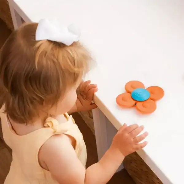 Child with fidget spinner on table