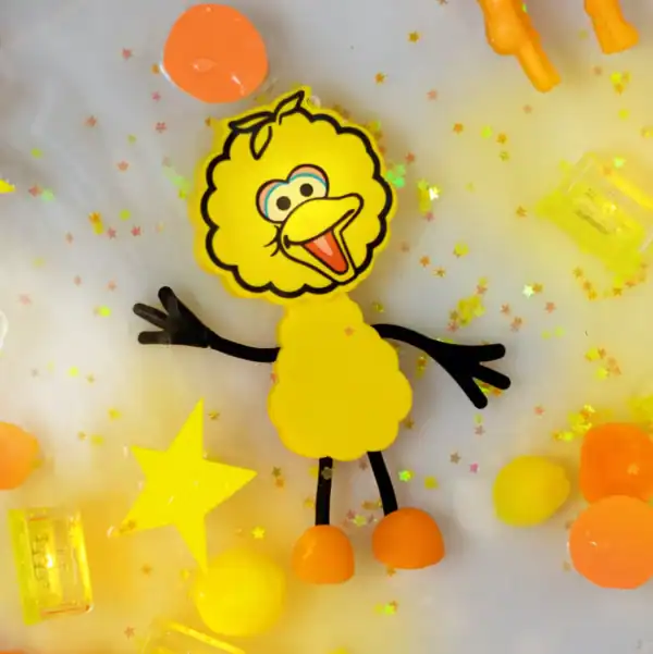 Yellow cartoon bird with colorful stars and shapes