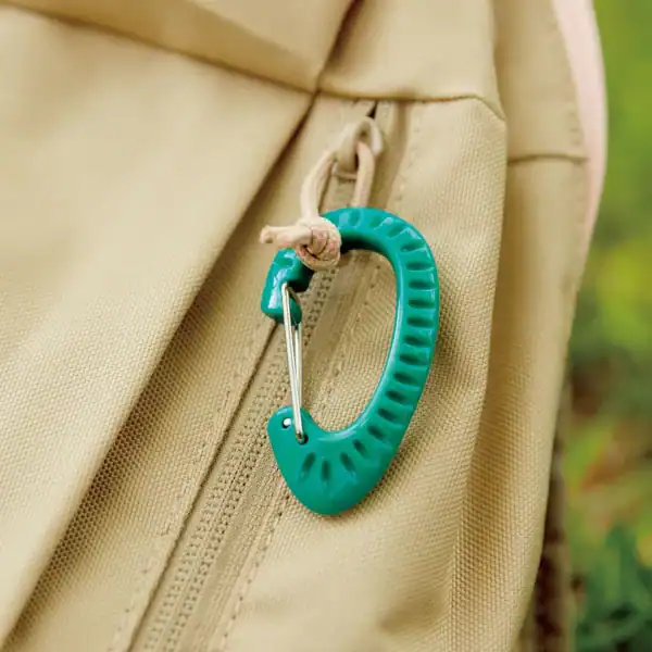 Green carabiner on beige backpack