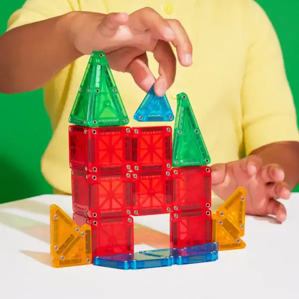 Child building with colorful magnetic tiles