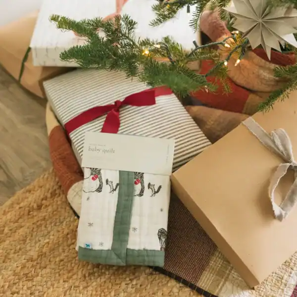 Christmas gifts under tree with baby quilt
