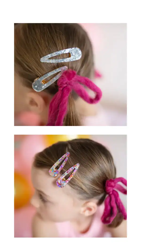Child's hair with decorative clips and pink ties.
