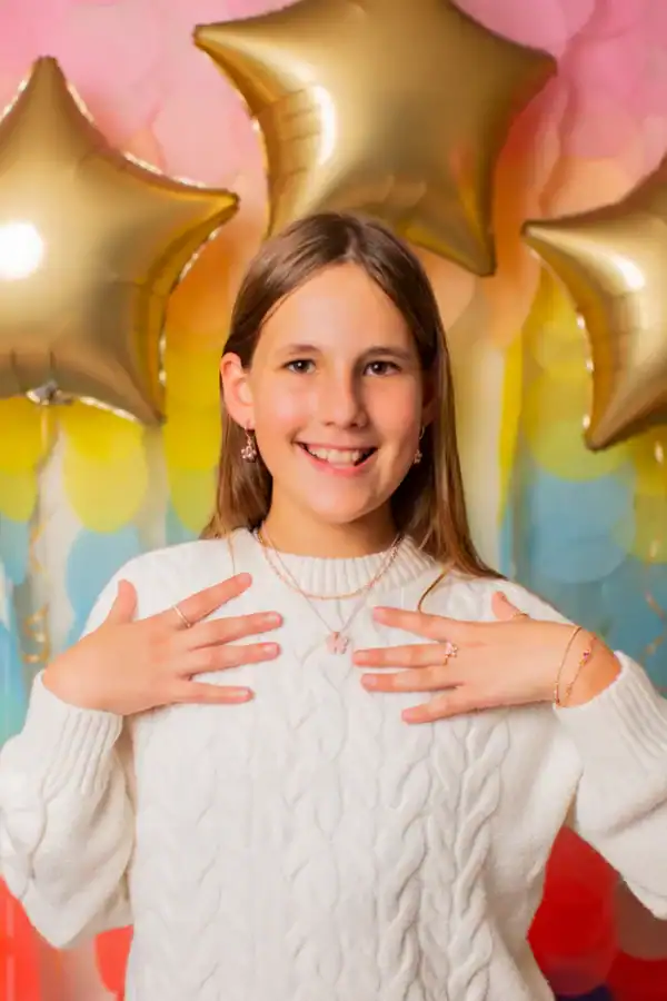 Smiling girl with jewelry and star balloons background.