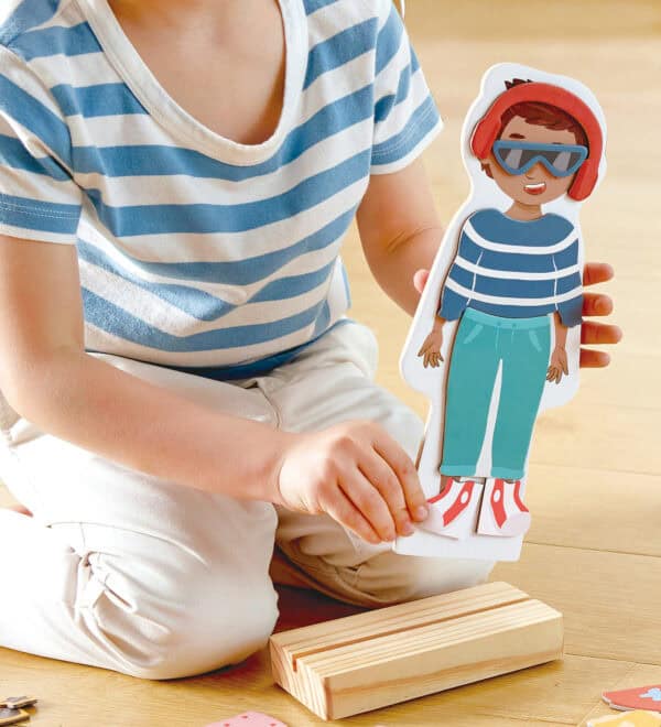 Child playing with diverse dress-up doll set.