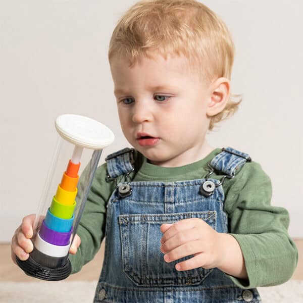 Toddler plays with colorful stacking toy.