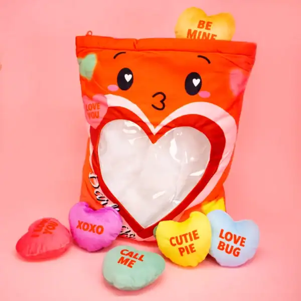 Heart-shaped plush with love messages on pink background.