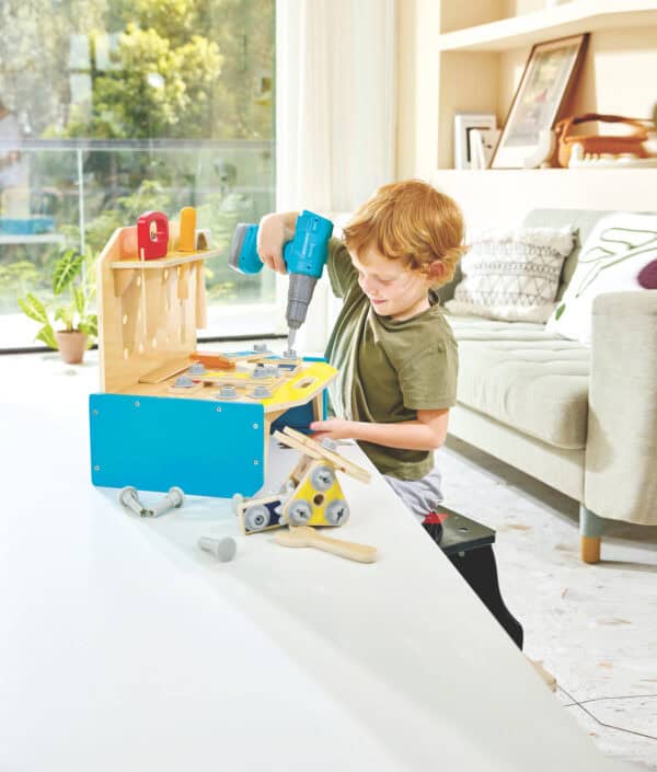 Child playing with wooden tool toy set indoors.