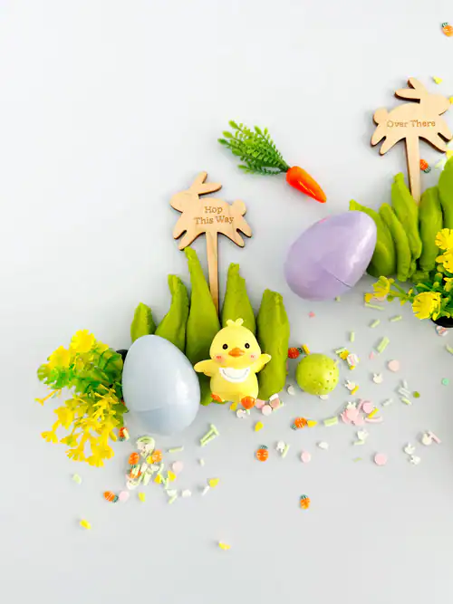 Easter eggs and decorations with toy chick and signs.