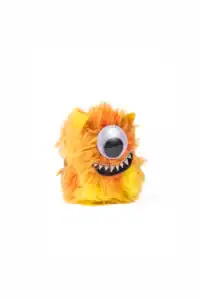 Fuzzy orange toy monster with one eye and teeth.