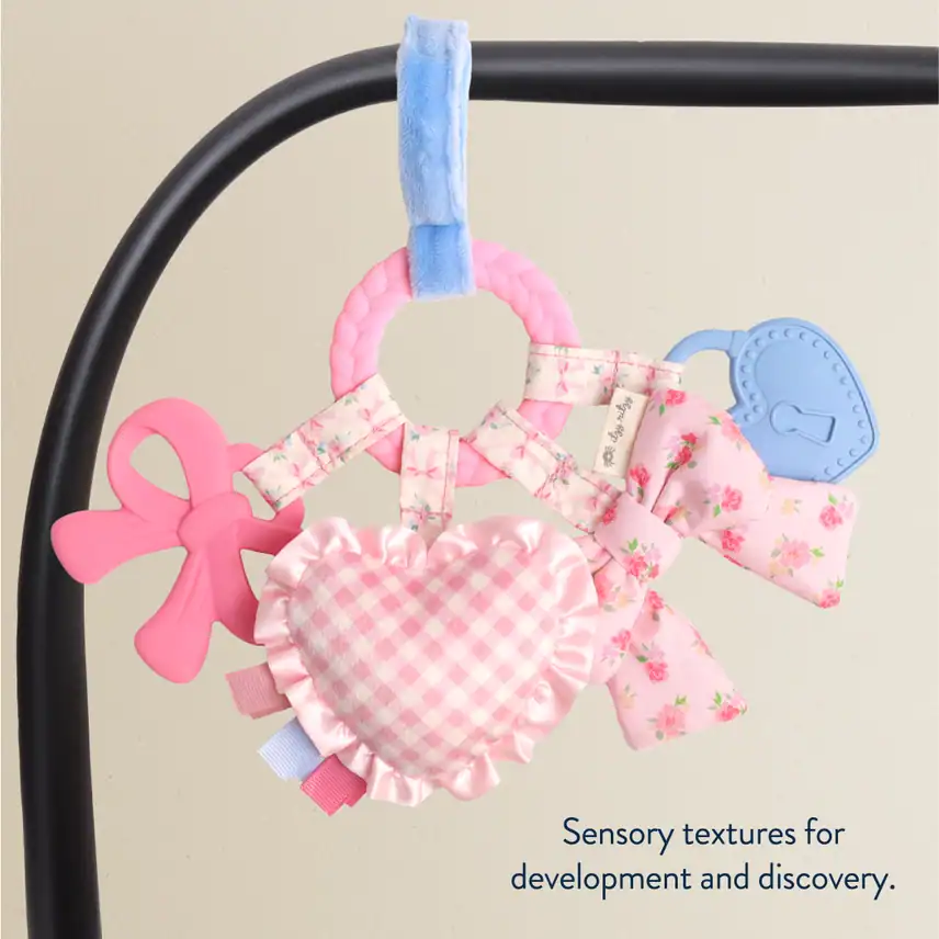 Baby toy with heart and bow, sensory textures.