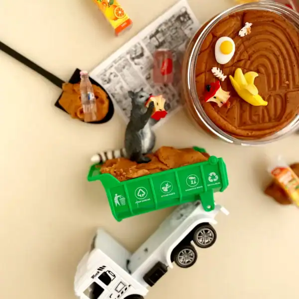 Toy garbage truck with playful raccoon figure