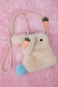 Furry bunny-shaped bag with carrot design, pink background.