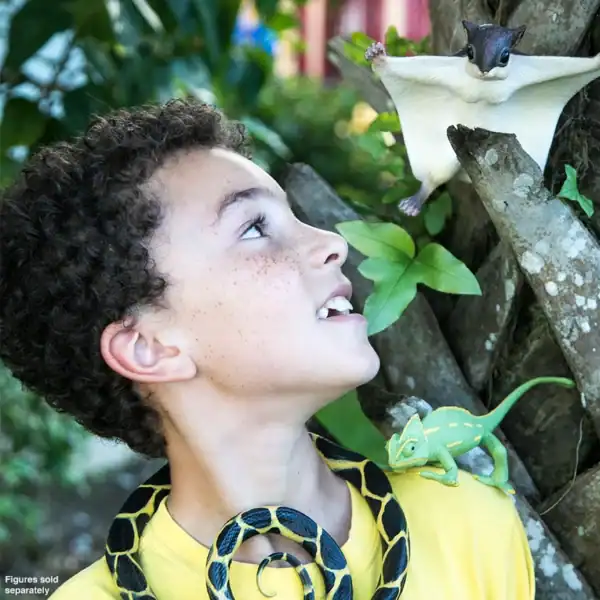 Child with toy animals in a tree
