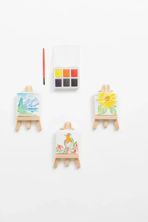 Mini easels with watercolor paintings and paint set